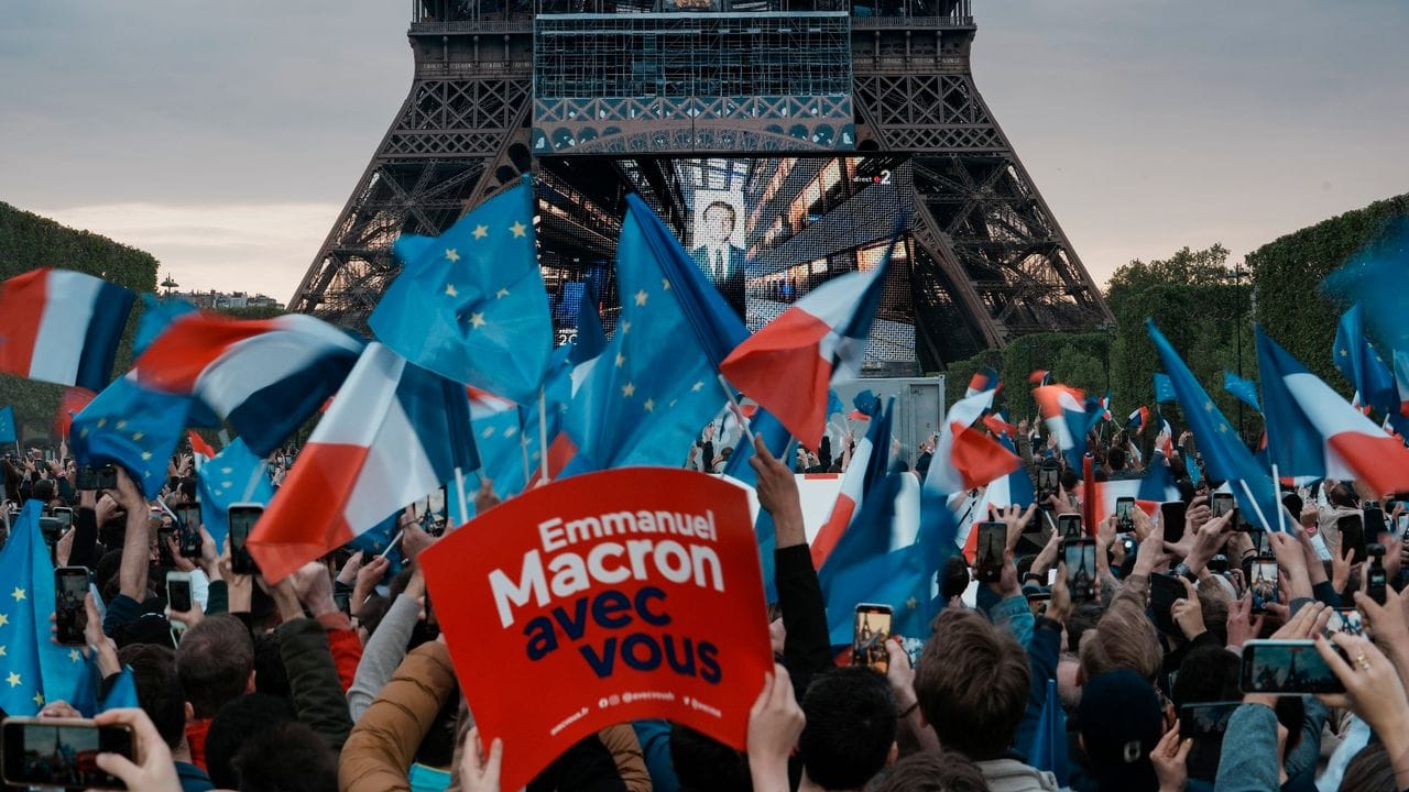 Anhänger des französischen Präsidenten Macron reagieren am Eiffelturm auf die Bekanntgabe der Wahlprognosen.
