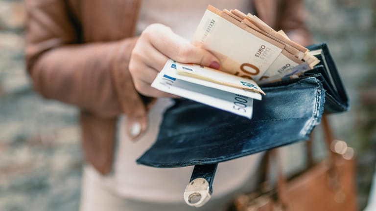 Eine Frau hält Euroscheine in der Hand (Symbolbild): Liegt die Inflation bei 8 Prozent, haben 100 Euro nach einem Jahr nur noch eine Kaufkraft von 92 Euro.