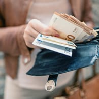 Eine Frau hält Euroscheine in der Hand (Symbolbild): Liegt die Inflation bei 8 Prozent, haben 100 Euro nach einem Jahr nur noch eine Kaufkraft von 92 Euro.
