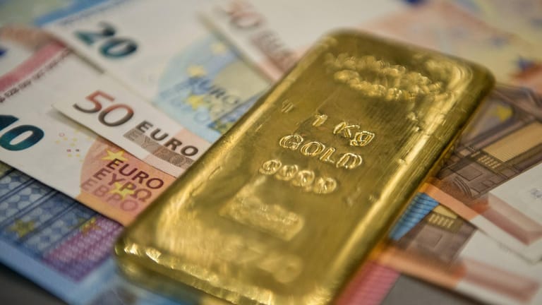 Goldbarren auf Geldscheinen (Symbolbild): Das Edelmetall bringt zwar keine regelmäßigen Erträge, kann das Portfolio aber stabilisieren.