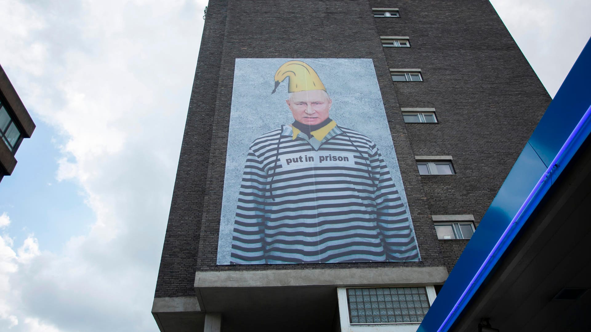 Russlands Präsident Wladimir Putin ist auf einem riesigen Protest-Plakat verewigt. Das XXL-Banner ziert eine Hauswand in der Kölner Innenstadt und ist schon von weitem gut sichtbar.