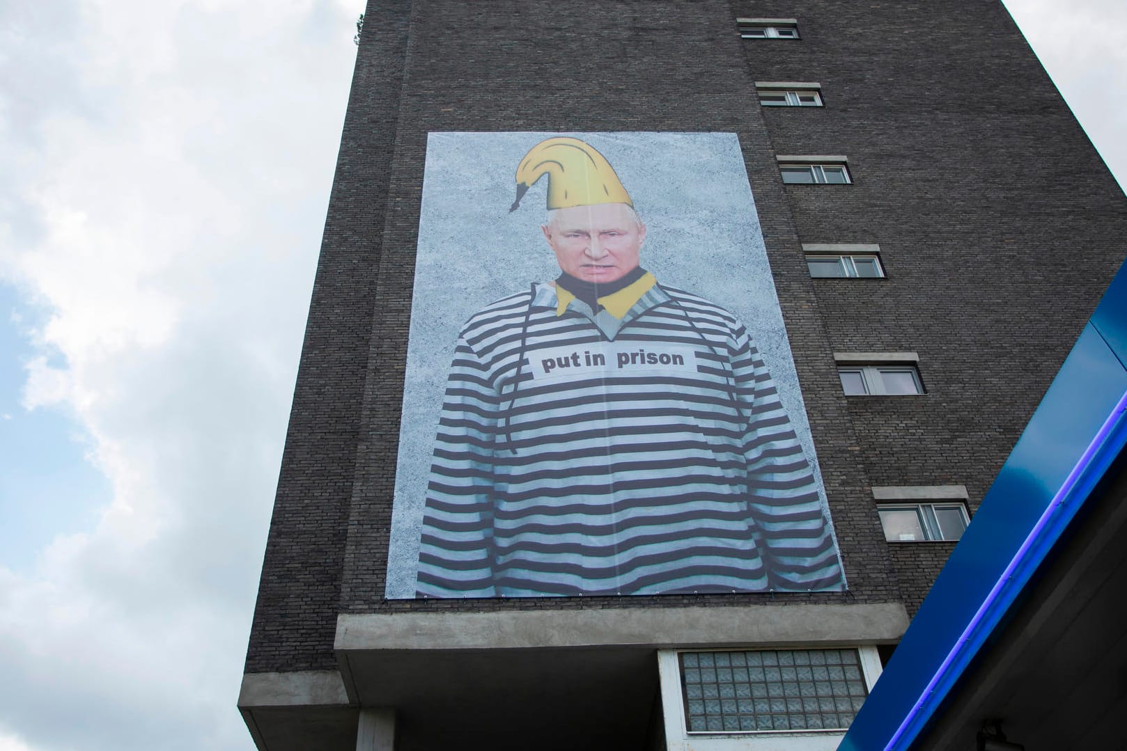 Russlands Präsident Wladimir Putin ist auf einem riesigen Protest-Plakat verewigt. Das XXL-Banner ziert eine Hauswand in der Kölner Innenstadt und ist schon von weitem gut sichtbar.