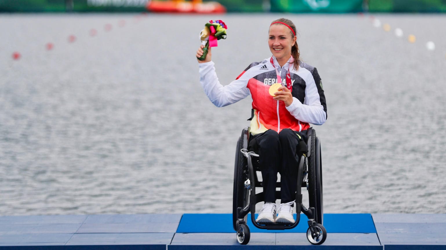 Edina Müller hält einen Blumenstrauß und eine Medaillein der Hand (Archivbild): Die Kanutin nahm ihre zweite Olympische Goldmedaille entgegen.