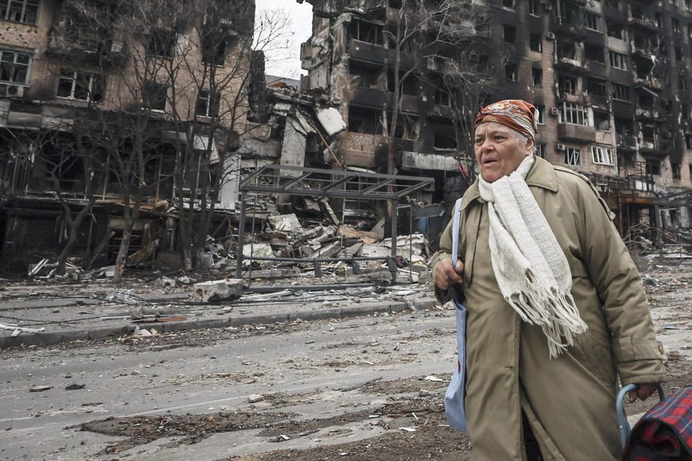 Eine Frau steht vor Trümmern in Mariupol: Viele Zivilisten suchen Schutz in Kellerräumen.