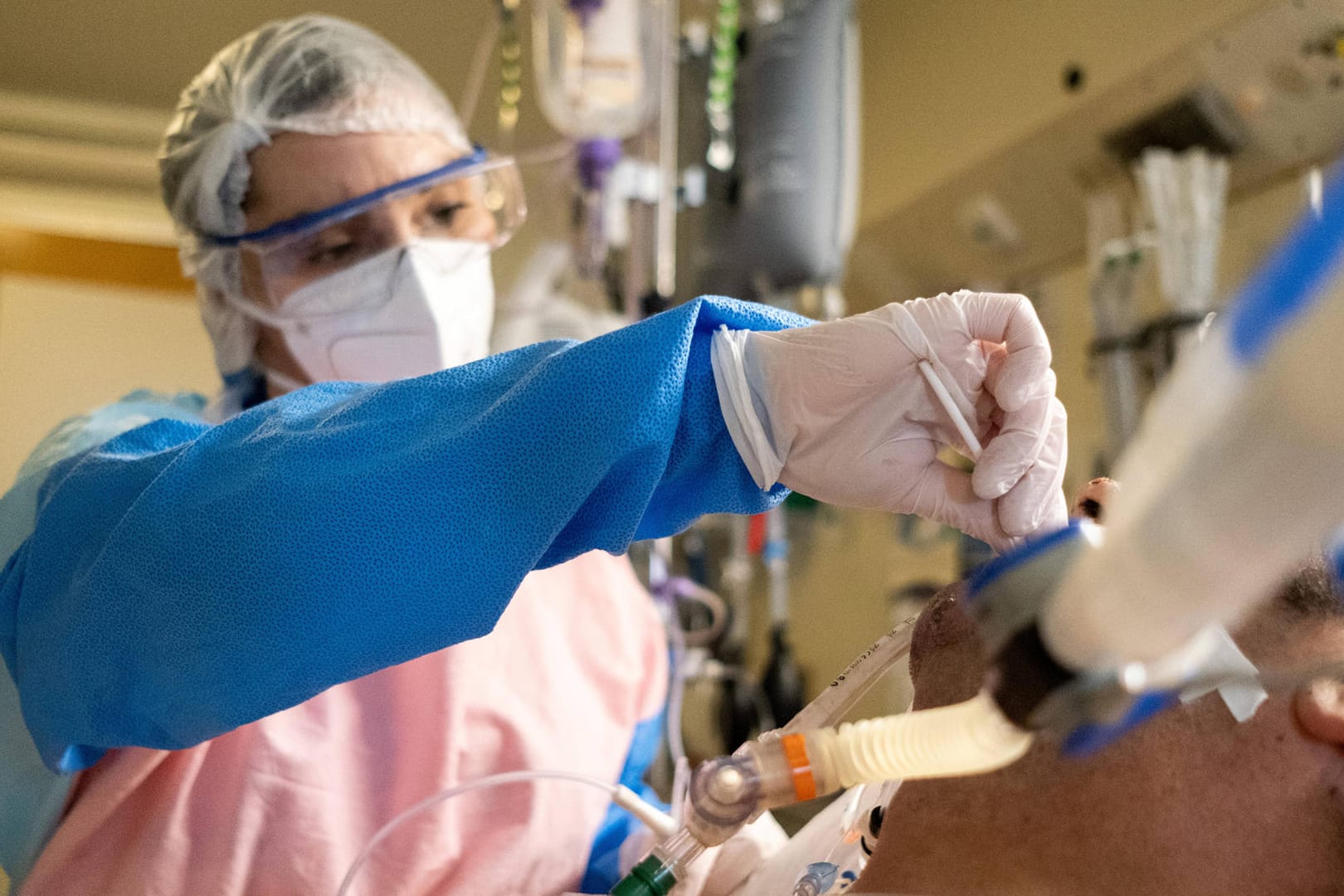 Eine Pflegerin reinigt den Beatmungsschlauch eines Corona-Patienten (Symbolbild): Noch immer sterben fast 300 Menschen in Deutschland pro Tag an den Folgen einer Infektion.