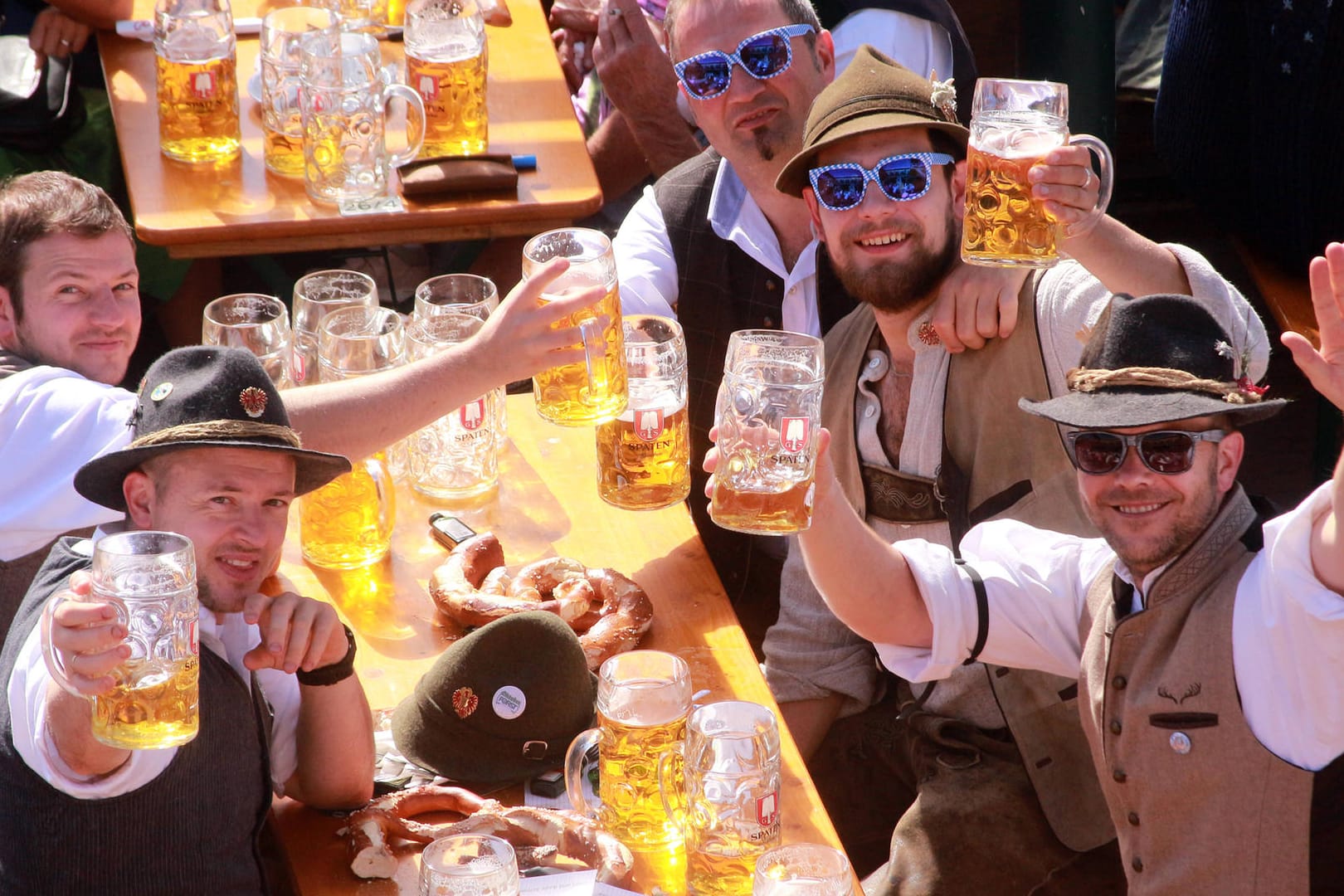 Gut gelaunte Oktoberfest-Besucher prosten in die Kamera (Archivbild): 2022 gibt es wieder Anlass zum Feiern auf der Theresienwiese, die Wiesn soll stattfinden.