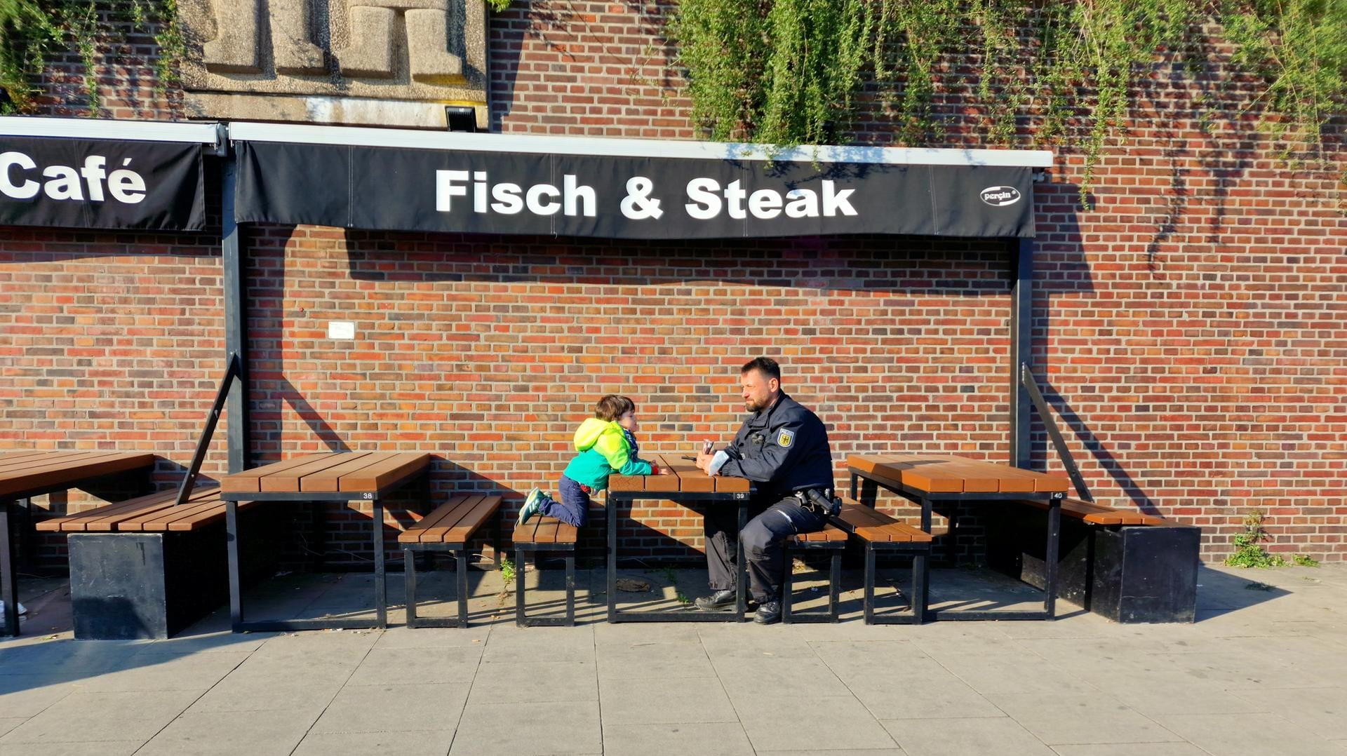 Der Junge mit einem Polizeibeamten: Zuvor war der Vierjährige an den Landungsbrücken verloren gegangen.