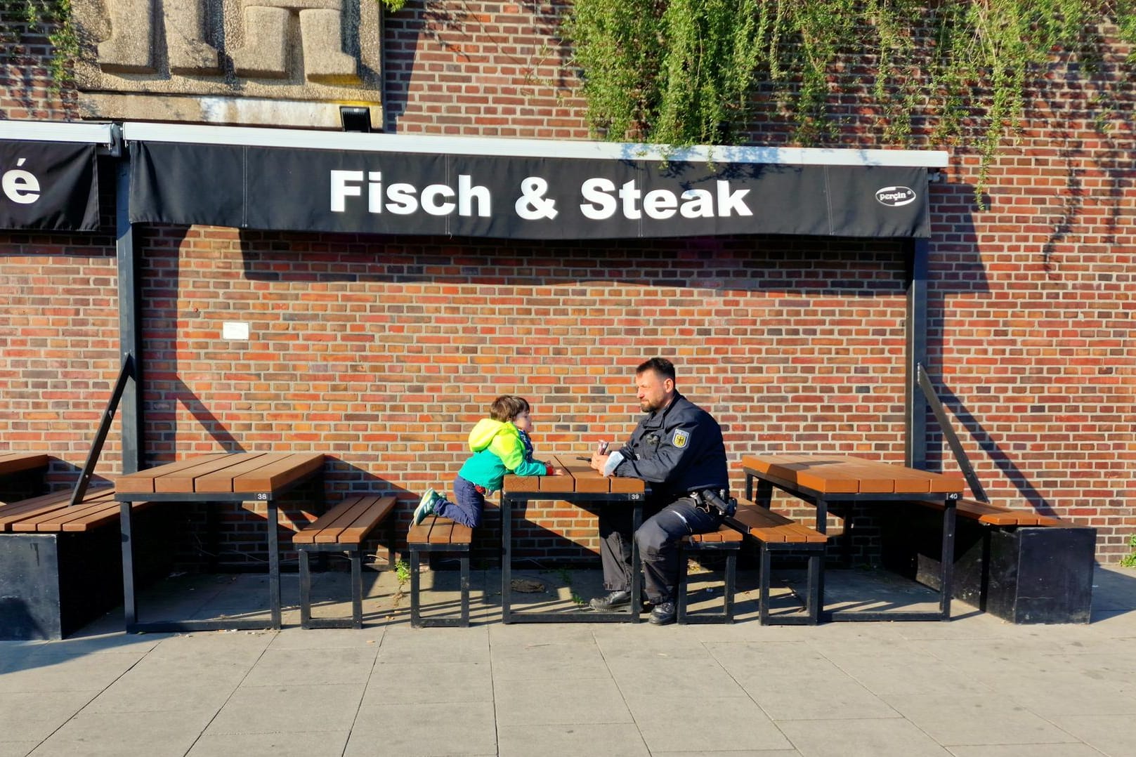 Der Junge mit einem Polizeibeamten: Zuvor war der Vierjährige an den Landungsbrücken verloren gegangen.