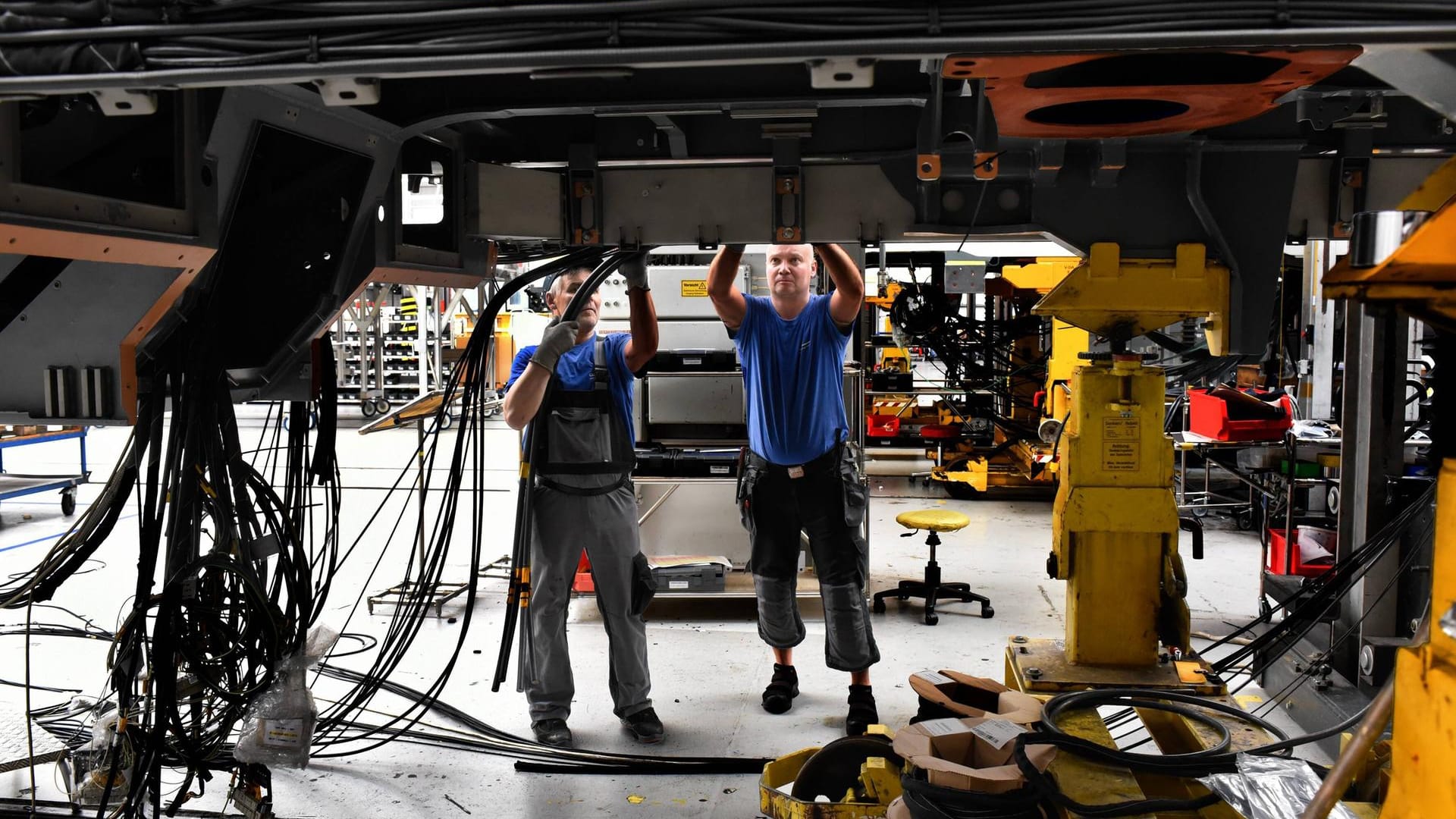 Zwei Mitarbeiter im Siemens-Werk in Krefeld (Symbolbild): Der Ukraine-Krieg macht sich in vielen Branchen bemerkbar und führt zu geringeren Erwartungen für das deutsche Wirtschaftswachstum.