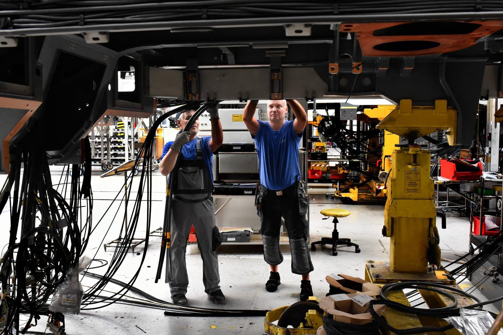 Zwei Mitarbeiter im Siemens-Werk in Krefeld (Symbolbild): Der Ukraine-Krieg macht sich in vielen Branchen bemerkbar und führt zu geringeren Erwartungen für das deutsche Wirtschaftswachstum.