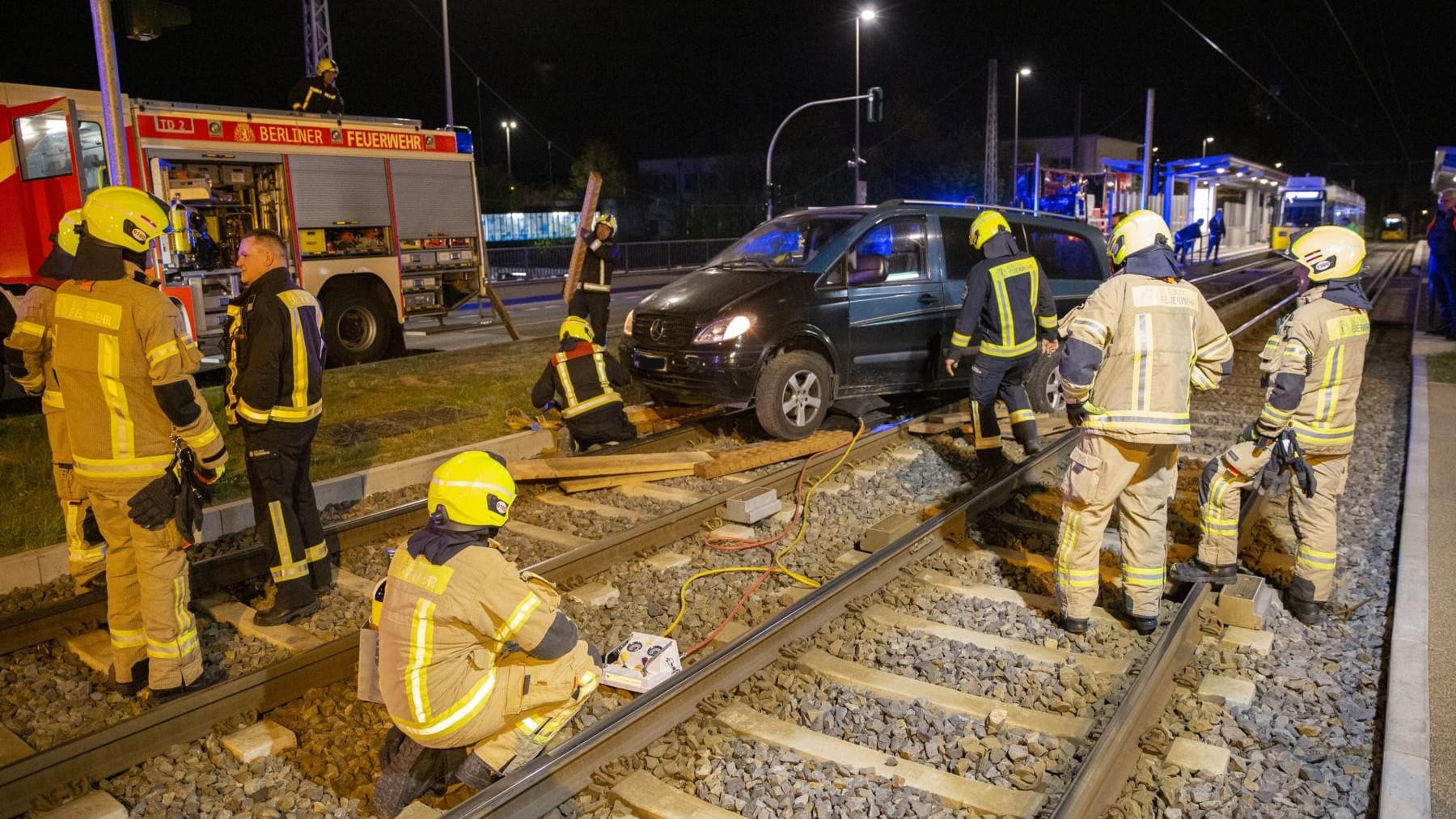 Feuerwehrkräfte versuchen, den Wagen aus dem Gleisbett zu bergen: Die schwere Beladung des Fahrzeugs verkomplizierte den Einsatz.