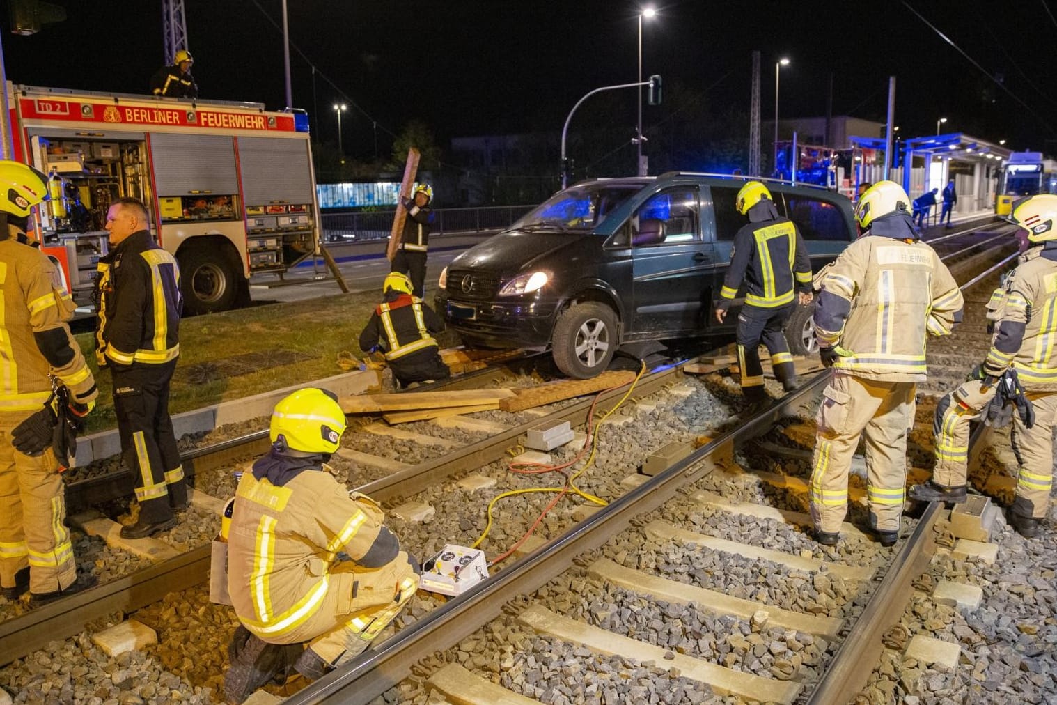 Feuerwehrkräfte versuchen, den Wagen aus dem Gleisbett zu bergen: Die schwere Beladung des Fahrzeugs verkomplizierte den Einsatz.