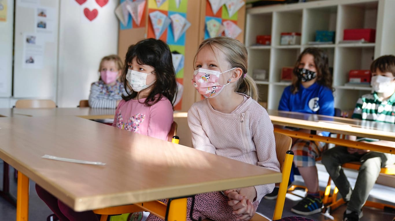 Grundschüler sitzen mit Masken im Klassenraum (Symbolbild): Ein Eilantrag gegen Maskenpflicht und Tests an Schulen in Hamburg war erfolgreich.
