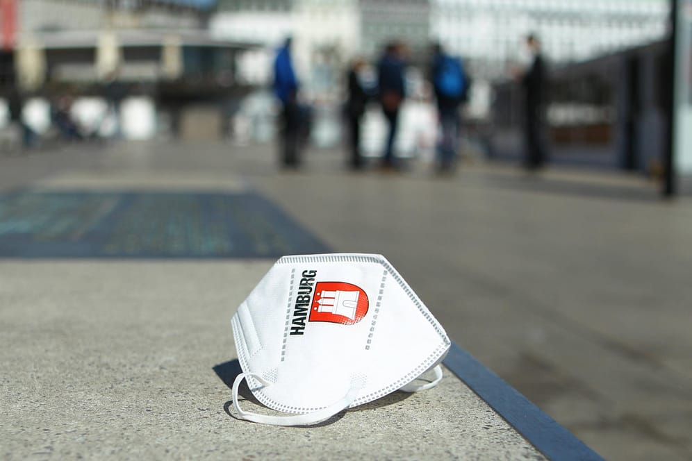 Eine Maske mit dem Logo von Hamburg liegt auf den Treppen am Jungfernstieg (Symbolbild): Die AfD Hamburg ist mit ihrem juristischen Vorgehen gegen die Corona-Hotspotregel gescheitert.