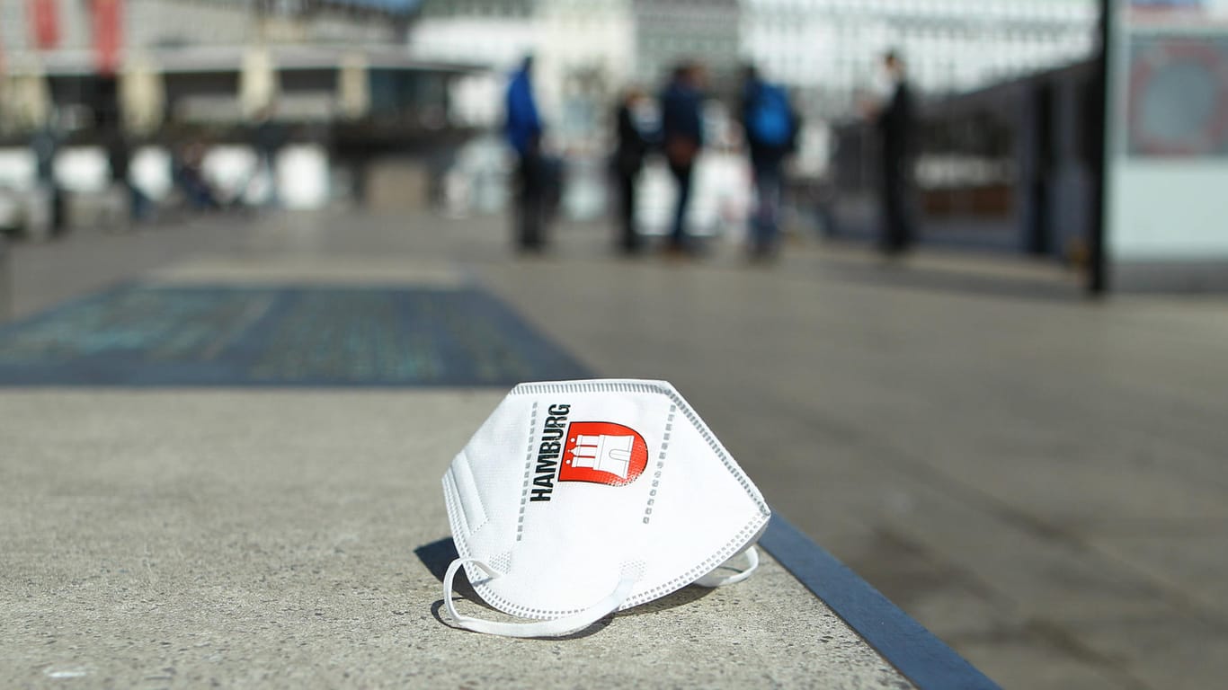 Eine Maske mit dem Logo von Hamburg liegt auf den Treppen am Jungfernstieg (Symbolbild): Die AfD Hamburg ist mit ihrem juristischen Vorgehen gegen die Corona-Hotspotregel gescheitert.