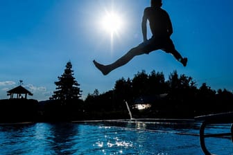 Ein Mann springt ins Schwimmbecken (Symbolbild): Nach und nach öffnen fast alle Freibäder ihre Tore.