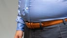 Mann mit dickem Bauch. Fettablagerungen im Bauchbereich sind oft die Folge von Stressessen.