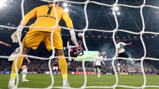 Der Torwart Kevin Trapp von Eintracht Frankfurt (vorn) schaut auf den Fallrückzieher von Jarrod Bowen von West Ham United.