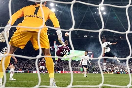 Der Torwart Kevin Trapp von Eintracht Frankfurt (vorn) schaut auf den Fallrückzieher von Jarrod Bowen von West Ham United.