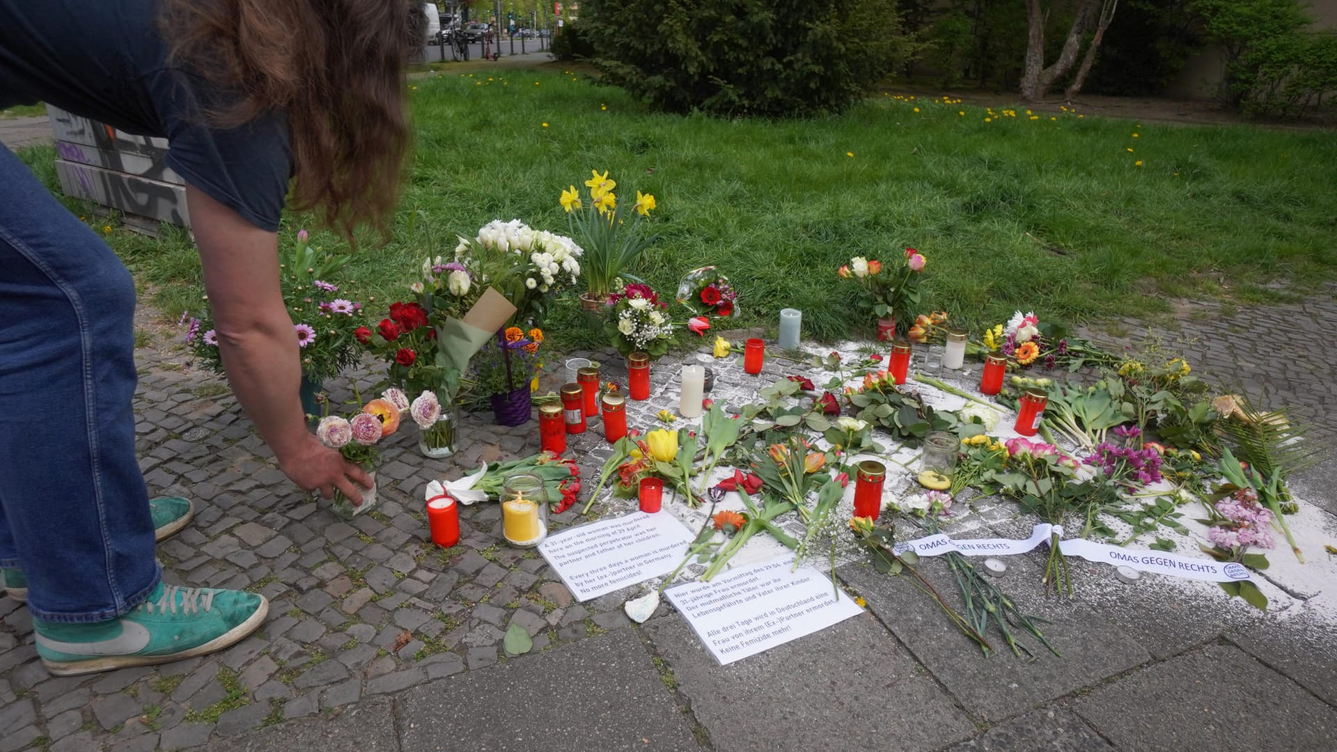 An dem Ort, wo eine sechsfache Mutter mit Messerstichen getötet wurde, legt ein Mann Blumen nieder: Nun sucht die Polizei nach Zeugen.