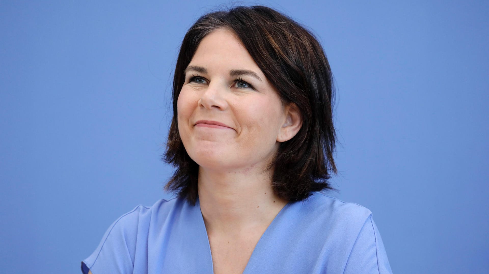 Außenministerin Annalena Baerbock sitzt in der Bundespressekonferenz: Wissen Sie über die Karriere und Forderungen von der Grünen-Politikerin Bescheid?