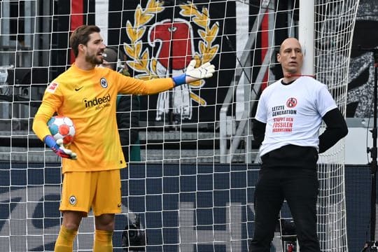 Frankfurts Torwart Kevin Trapp (l) diskutiert mit einem der Protestler.