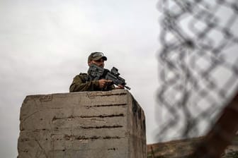 Ein bewaffneter israelischer Soldat hält auf seinem Posten in Hebron Wache.