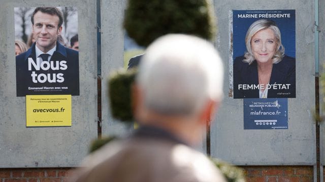 Ein Mann geht an Wahlkampfplakaten für die Präsidentschaftswahl in Frankreich vorbei. Ein Mann geht an Wahlkampfplakaten für die Präsidentschaftswahl in Frankreich vorbei.