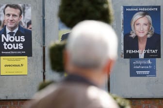 Ein Mann geht an Wahlkampfplakaten für die Präsidentschaftswahl in Frankreich vorbei.