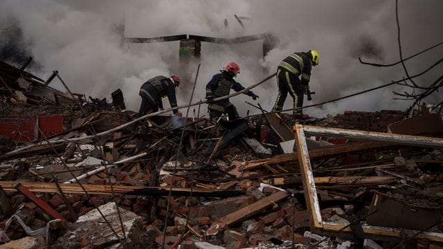 Feuerwehrleute arbeiten daran, ein Feuer nach einem russischen Angriff in Charkiw zu löschen.