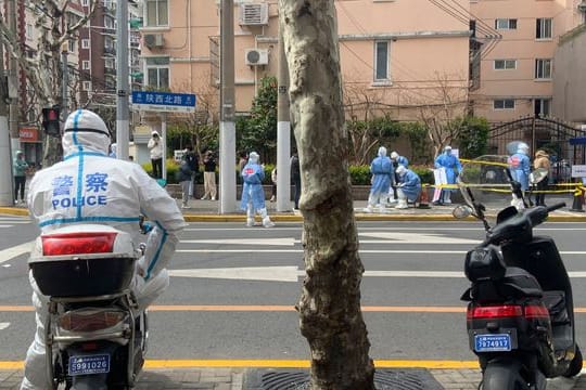 Ein Polizist in Schutzkleidung steht Wache im Jingan-Bezirk in Shanghai.