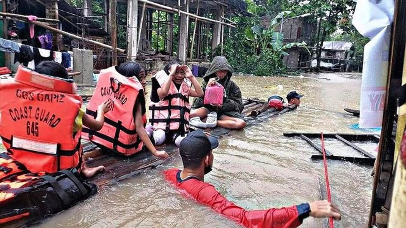 Retter evakuieren die Bewohner eines überschwemmten Dorfes in Panitan auf der Insel Panay.