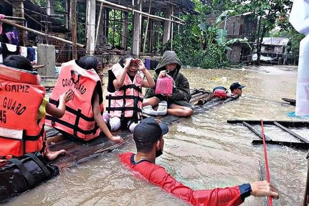 Retter evakuieren die Bewohner eines überschwemmten Dorfes in Panitan auf der Insel Panay.