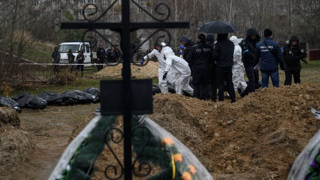 Personen in Schutzkleidung tragen die Leichen getöteter Zivilisten in Butscha am Stadtrand von Kiew.