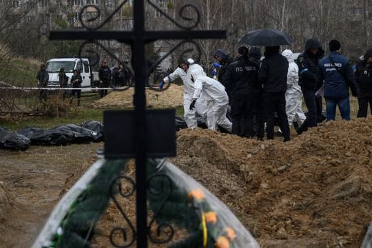 Personen in Schutzkleidung tragen die Leichen getöteter Zivilisten in Butscha am Stadtrand von Kiew.