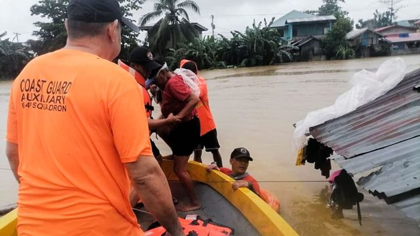 Mitglieder der philippinischen Küstenwache retten Bewohner in der philippinischen Provinz Capiz vor den Fluten.
