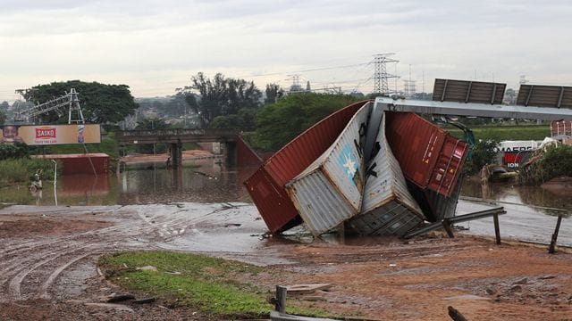 Beschädigte Schiffscontainer sind durch ungewöhnlich heftige Niederschläge weggetragen und zerstört worden. Beschädigte Schiffscontainer sind durch ungewöhnlich heftige Niederschläge weggetragen und zerstört worden.