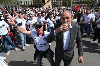 Eintracht-Präsident Peter Fischer (r) trinkt mit den angereisten Eintracht-Fans am Treffpunkt Placa de Catalunya ein Bier.