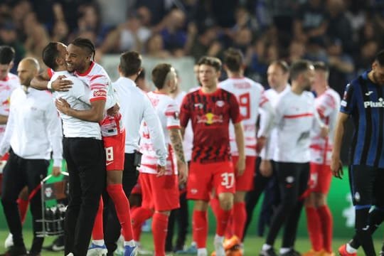 Leipzigs Christopher Nkunku jubelt mit Trainer Domenico Tedesco (l) nach dem Sieg in Bergamo.