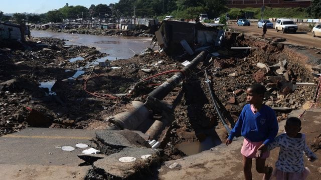 Kinder auf einer durch Überschwemmungen beschädigten Straße in Durban.