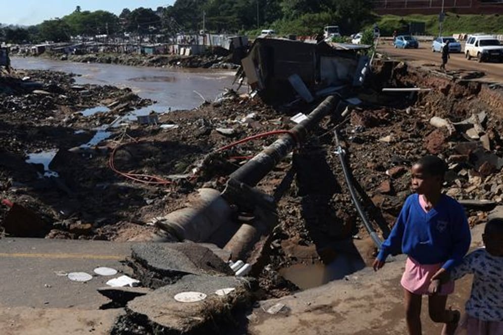 Kinder auf einer durch Überschwemmungen beschädigten Straße in Durban.