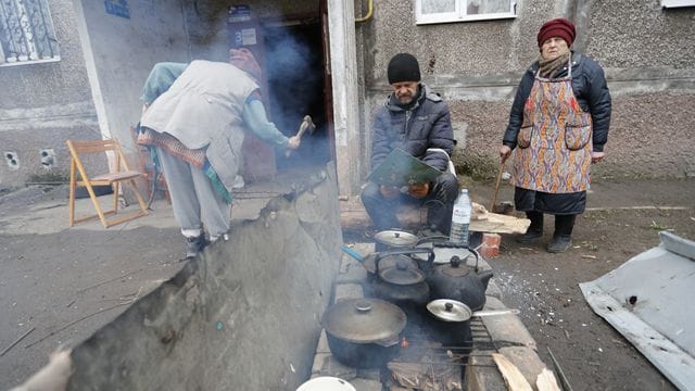 Einwohner kochen in Mariupol im Freien.