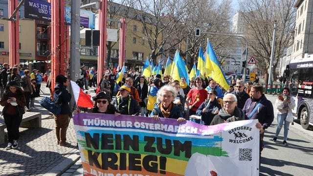 Teilnehmer eines Ostermarsches laufen in Jena nach einer Kundgebung auf dem Holzmarkt durch die Innenstadt.