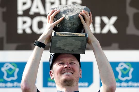 Dylan van Baarle aus den Niederlanden hält nach seinem Sieg die Trophäe, den Pflasterstein.