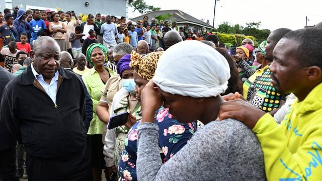 Der südafrikanische Präsident Cyril Ramaphosa spricht in dem Ort Durban mit trauernden Familienmitgliedern. Der südafrikanische Präsident Cyril Ramaphosa spricht in dem Ort Durban mit trauernden Familienmitgliedern.