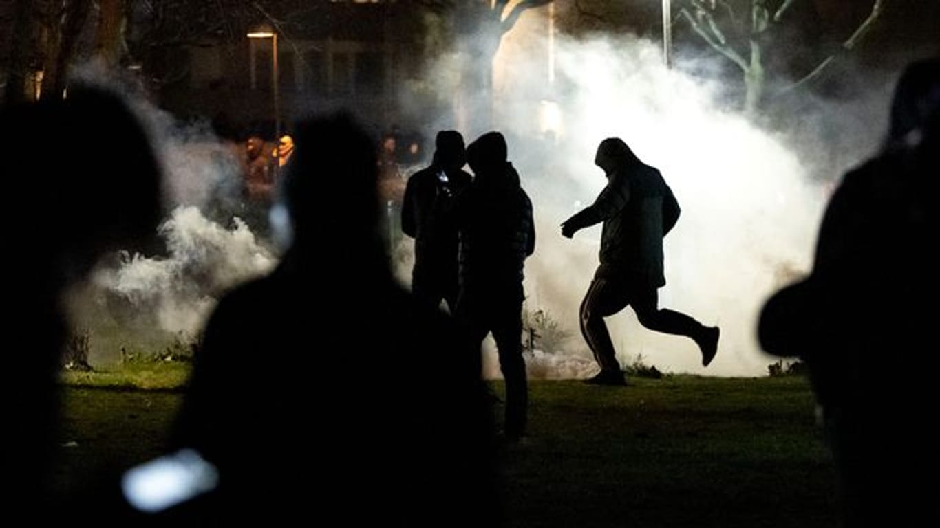 Menschen werden von Rauch umhüllt, nachdem im Stadtteil Rosengard in Malmö Proteste ausgebrochen sind.