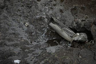Ein Teil einer Artilleriegranate steckt in Charkiw im Boden.