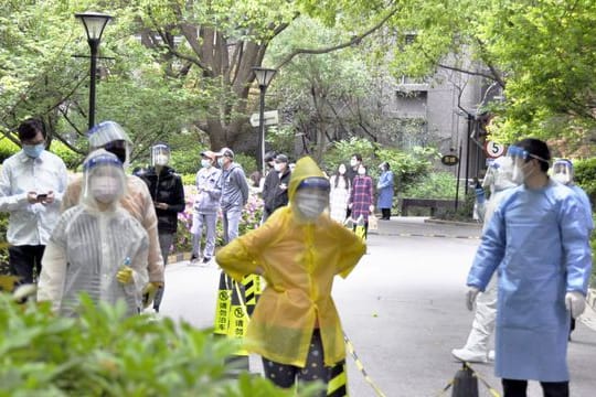 Bewohner einer Wohnanlage in Shanghai warten auf die Durchführung von PCR-Tests.