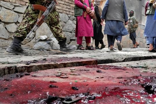 Taliban-Kämpfer stehen Wache am Ort der Explosion vor einer Schule in Kabul.