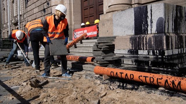 Aktivisten vom Bündnis "Letzte Generation" reißen den Gehweg vor dem Bundeswirtschaftsministerium auf, um Rohre für die symbolische Pipeline "Katar-Stream" zu verlegen.